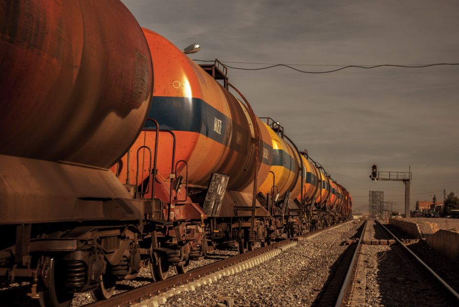 Imagem de um trem de carga com vagões coloridos, simbolizando transporte e logística de grandes volumes de commodities.