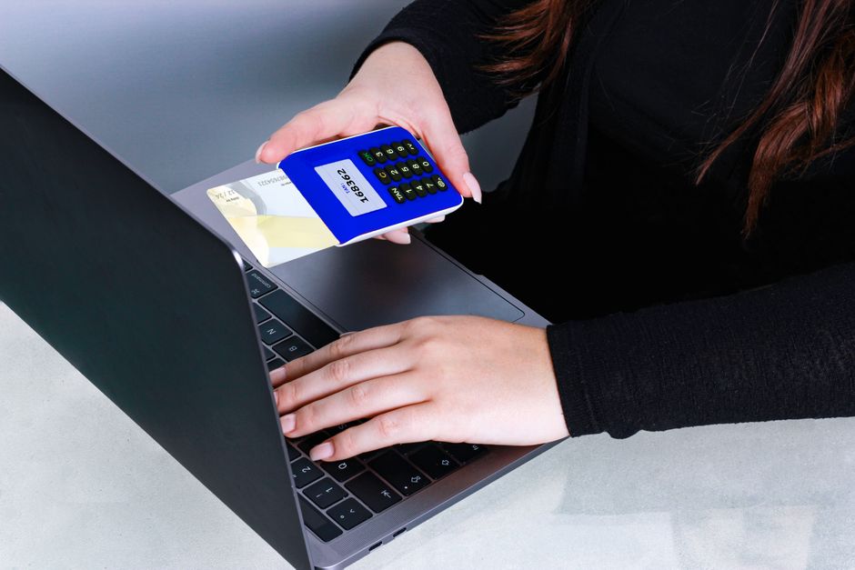 Imagem de uma pessoa realizando uma operação de pagamento com cartão no computador, representando transações financeiras online.