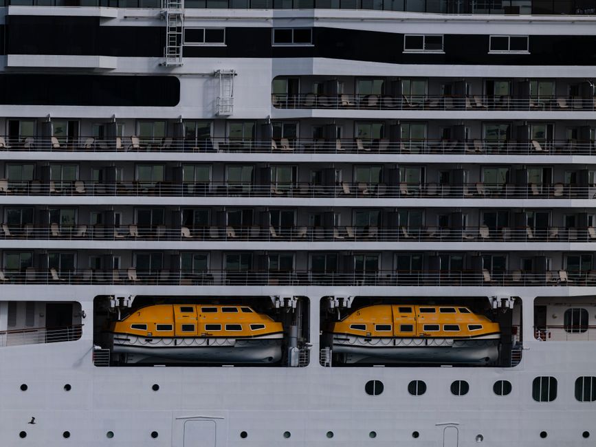 Imagem de um navio de cruzeiro com balsas salva-vidas visíveis na lateral para ilustrar segurança e infraestrutura marítima.