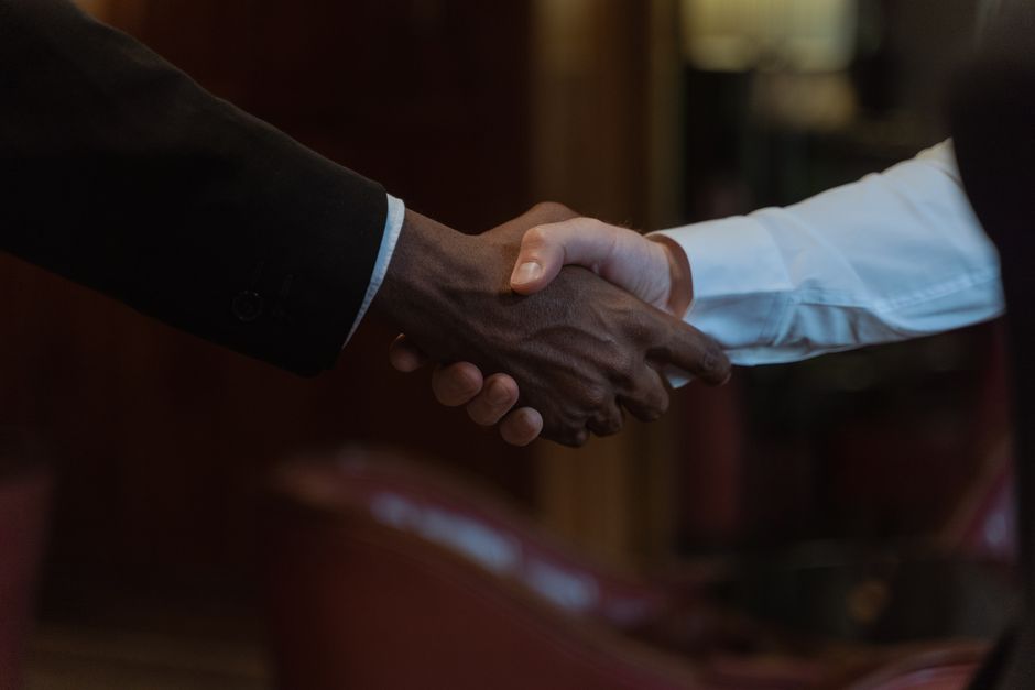 Imagem de um aperto de mãos entre duas pessoas, simbolizando parceria ou acordo de negócios.