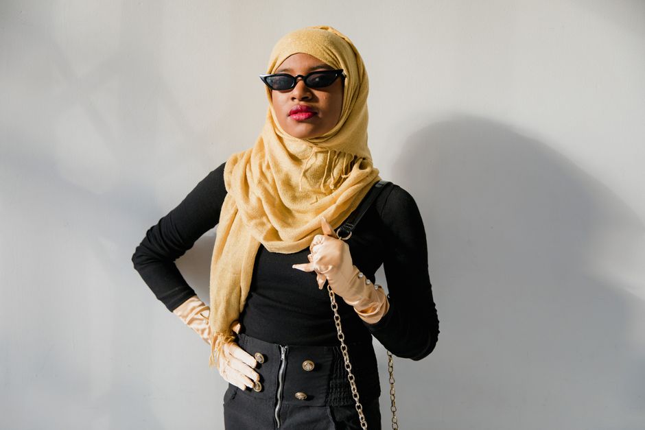 Mulher estilosa usando acessórios de moda, óculos escuros e hijab, transmitindo confiança e personalidade para um conteúdo de estilo e cultura.