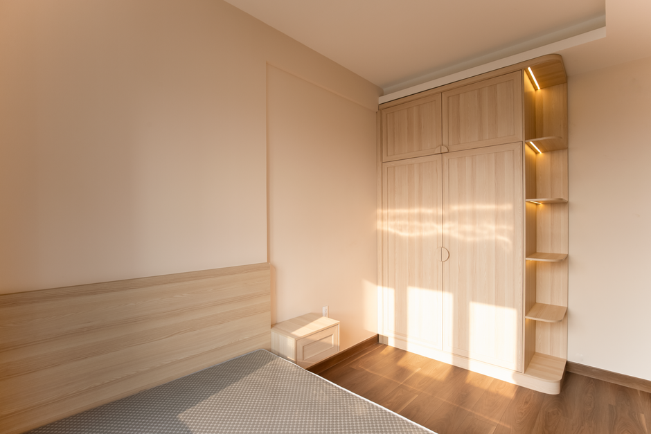 Quarto minimalista com armário de madeira e iluminação suave, ideal para ambientes de descanso e organização pessoal.