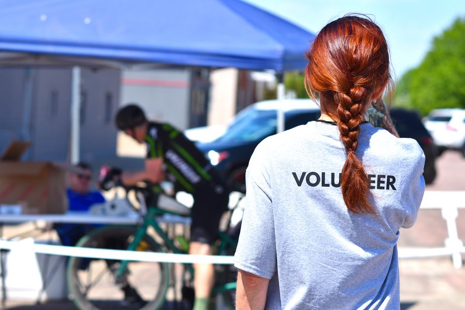 Voluntária observando uma arrecadação de doações em um evento ao ar livre, promovendo solidariedade e ajuda comunitária.