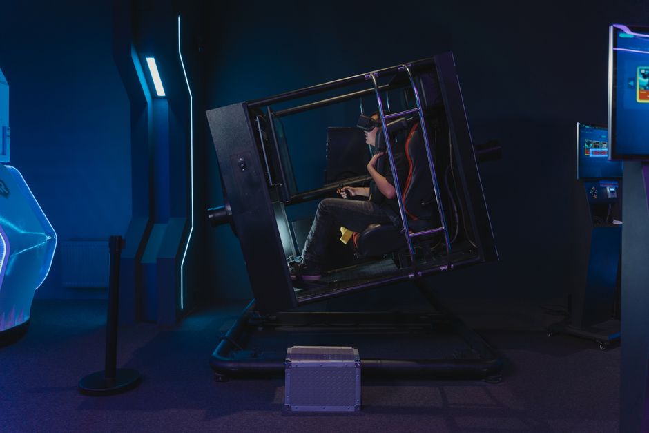 Pessoa usando óculos de realidade virtual em uma experiência imersiva dentro de um ambiente tecnológico escuro e futurista.