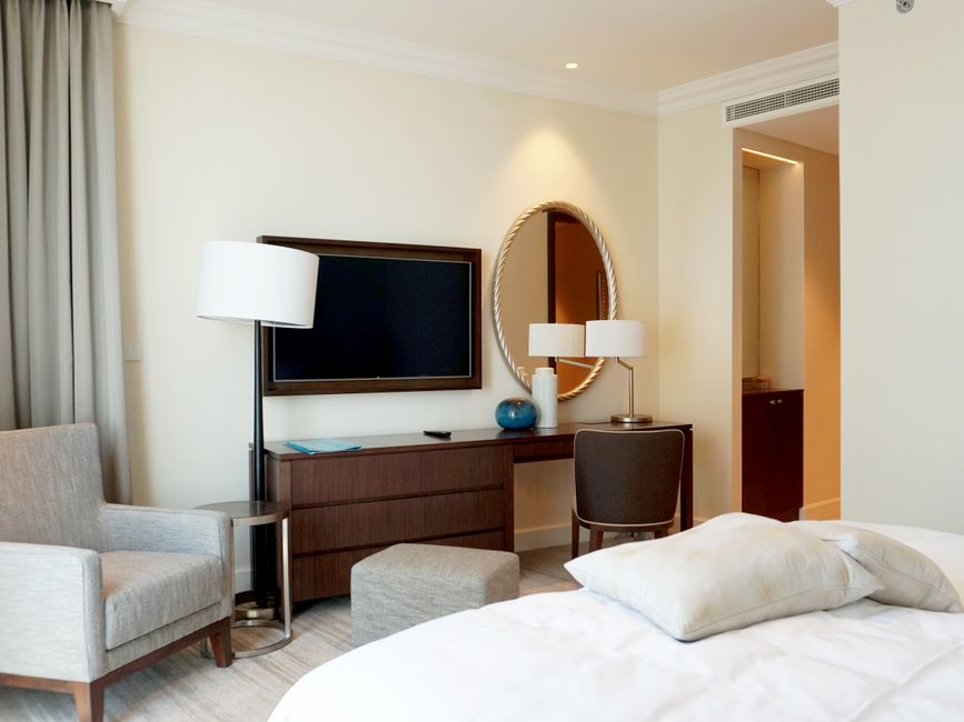 Quarto de hotel moderno com decoração elegante, destacando elementos de conforto e ambientação acolhedora.