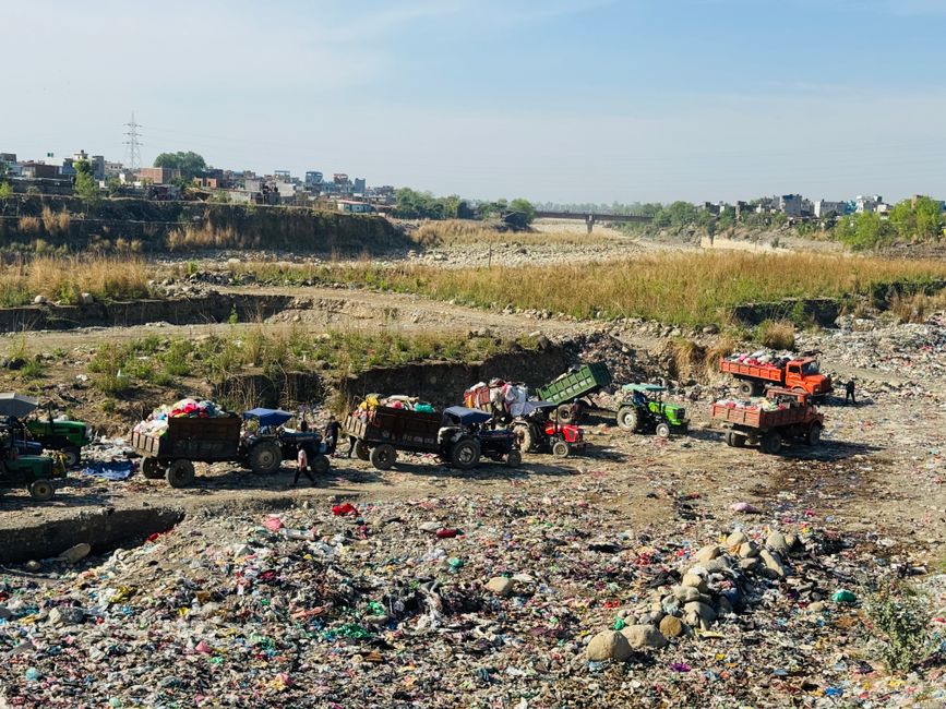 Caminhão de lixo em operação na gestão de resíduos sólidos em uma área urbana degradada.