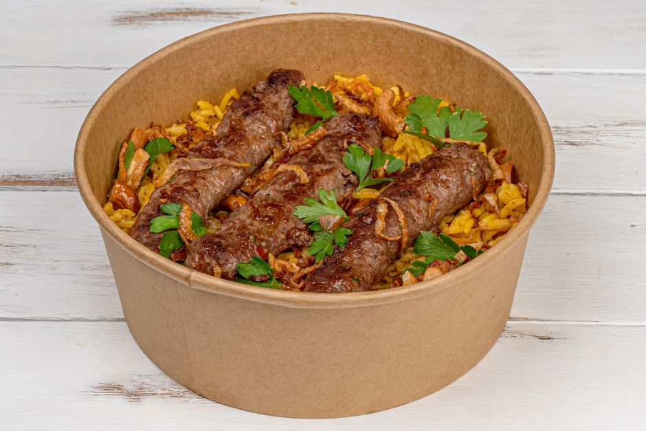 Prato de comida caseira com rolinhos de carne e arroz, decorado com folhas de salsa, ideal para um artigo sobre culinária tradicional brasileira.