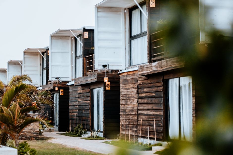 Imagem de um conjunto de casas modernas com design sustentável e uso de materiais naturais, refletindo inovação na habitação.