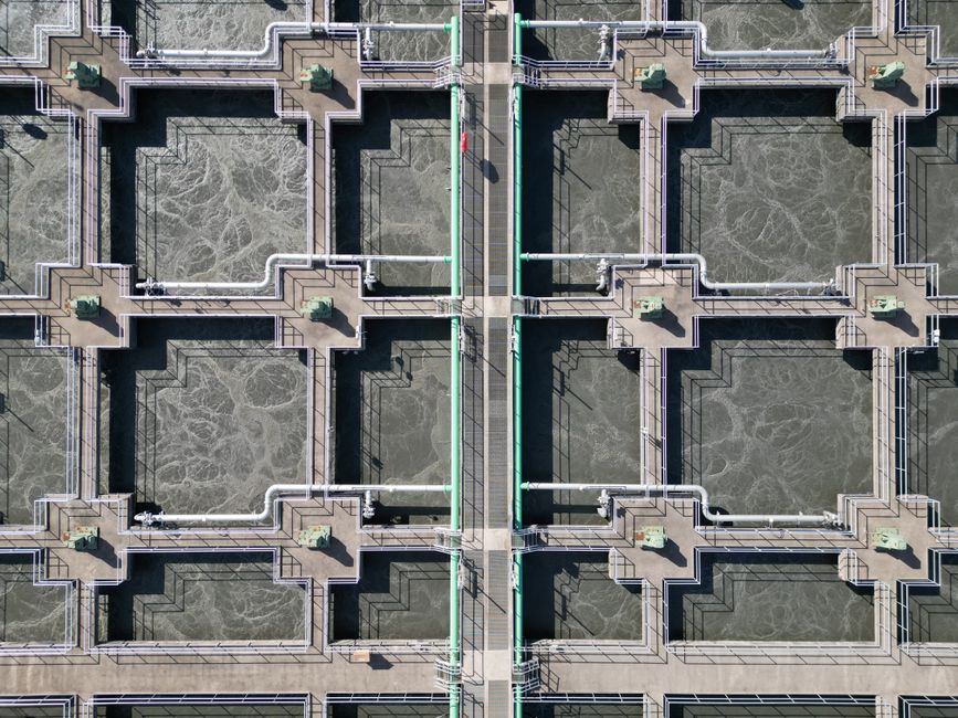 Imagem de uma estação de tratamento de águas, destacando os tanques e estruturas de circulação de líquidos.