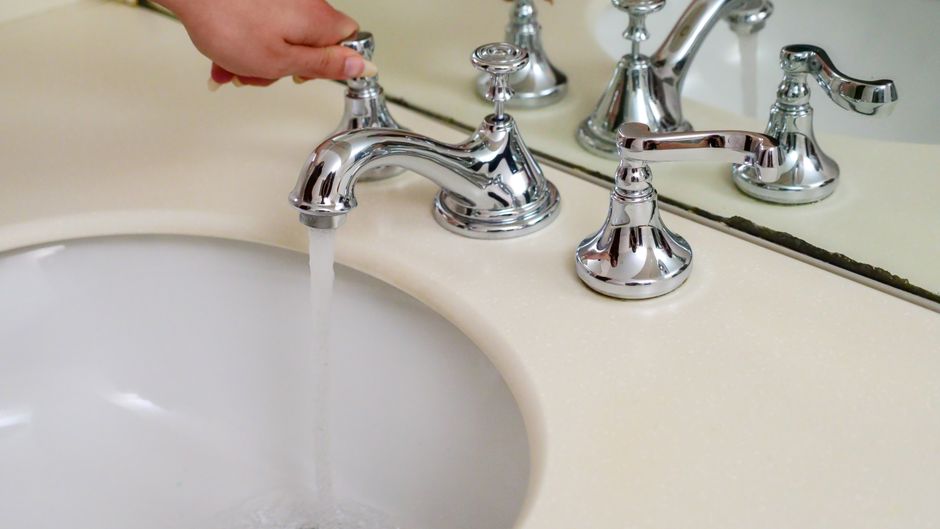 Imagem de uma torneira de humor com água sendo despejada em uma pia, destacando a expressão facial de surpresa ou desânimo.