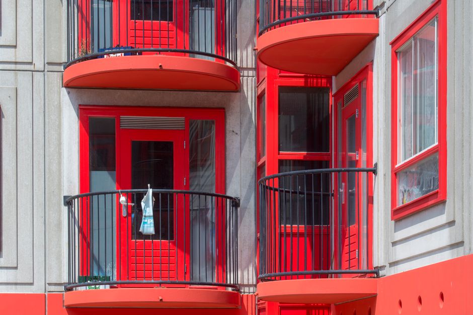Fachada de um edifício residencial com destaque para os detalhes arquitetônicos e cores vibrantes das janelas e varandas.