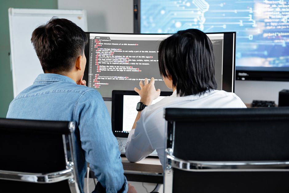 duas pessoas colaborando em um projeto de programação de software em ambiente de escritório