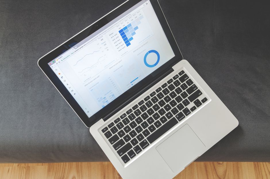 Imagem de um laptop exibindo gráficos e análises de dados, representando análise financeira ou de negócios.