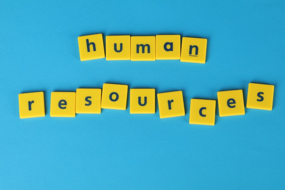 Imagem com blocos de letras formando a frase 'human resources' em um fundo azul, representando o tema de gestão de pessoas e recursos humanos.