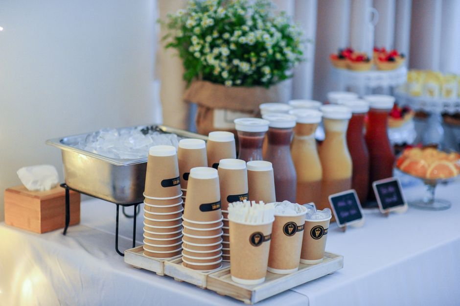 Mesa de café da manhã com bebidas e guloseimas, ideal para eventos sociais ou confraternizações.