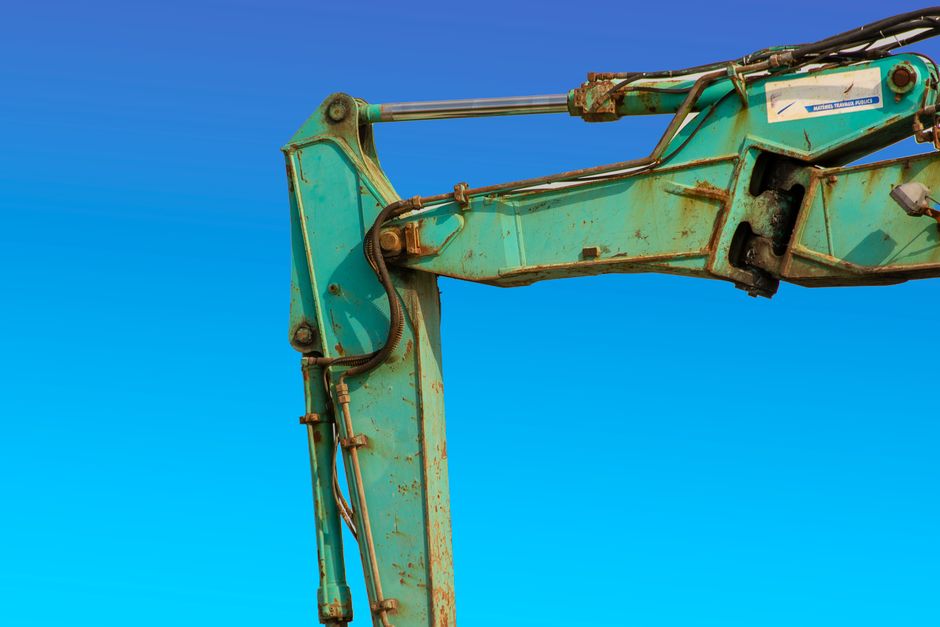 Estrutura metálica de uma maquinaria pesada em destaque contra um céu azul claro, simbolizando construção e indústria.