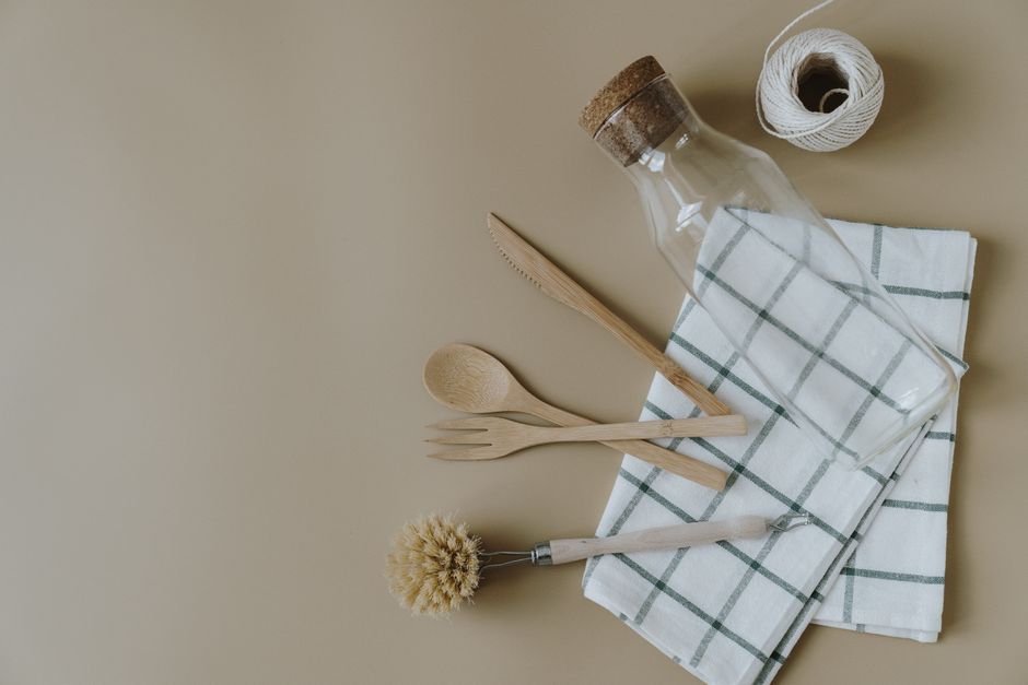 Imagem minimalista com utensílios de cozinha sustentáveis dispostos sobre uma toalha xadrez, simbolizando uma abordagem ecológica na gastronomia.