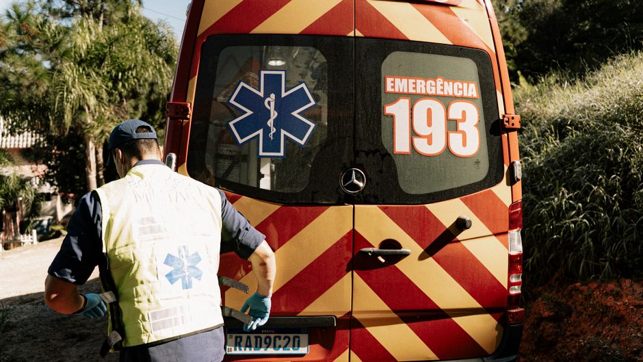 Profissional de saúde atendendo em ambiente de emergência com unidade móvel de suporte médico.