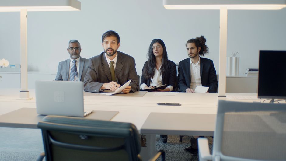 Grupo de profissionais participando de uma reunião de negócios em um ambiente corporativo moderno.