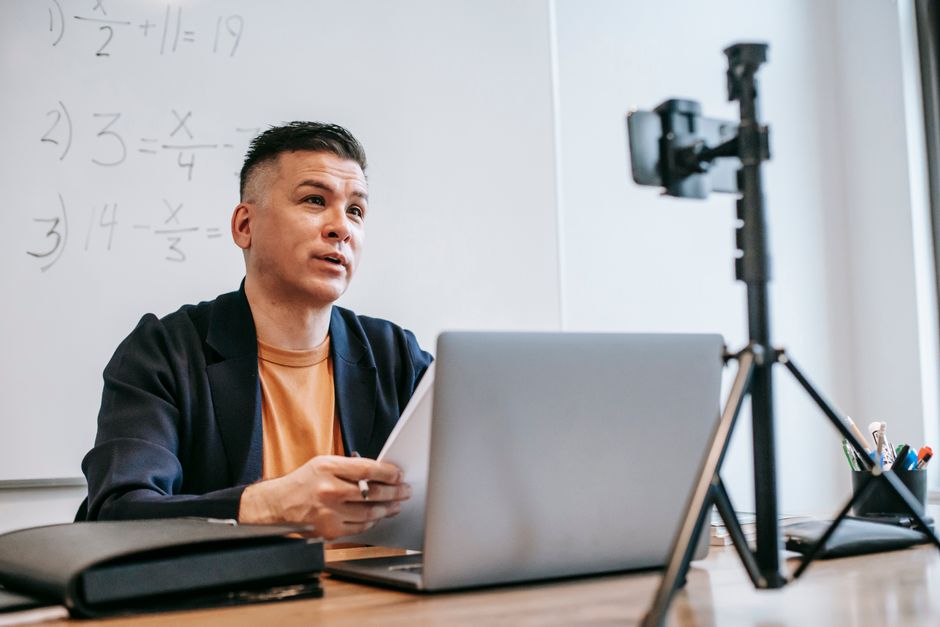 Professor ou tutor ministrando aula de matemática de forma remota, via gravação ou transmissão online em sala de aula virtual.