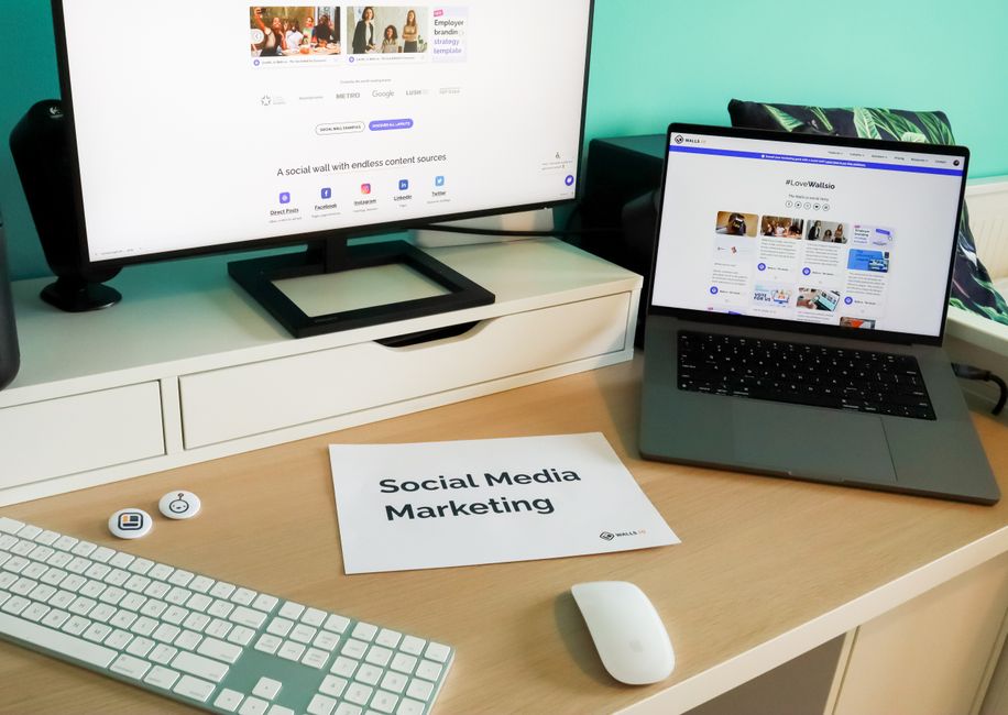 Configuração de espaço de trabalho para estratégias de marketing de mídia social, com computadores exibindo conteúdo digital.