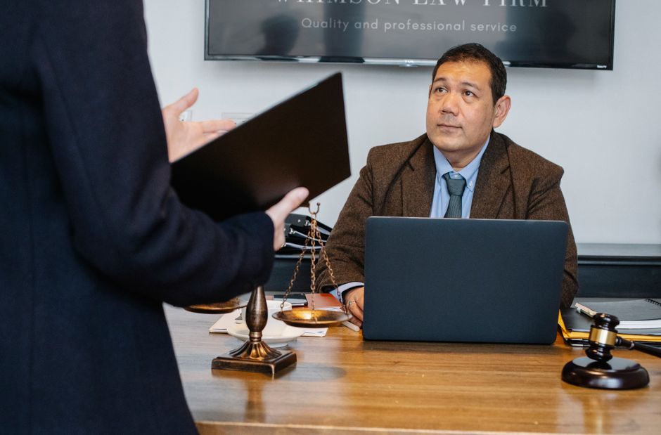 Homem em entrevista de emprego ou sessão de aconselhamento jurídico em um escritório de advocacia.