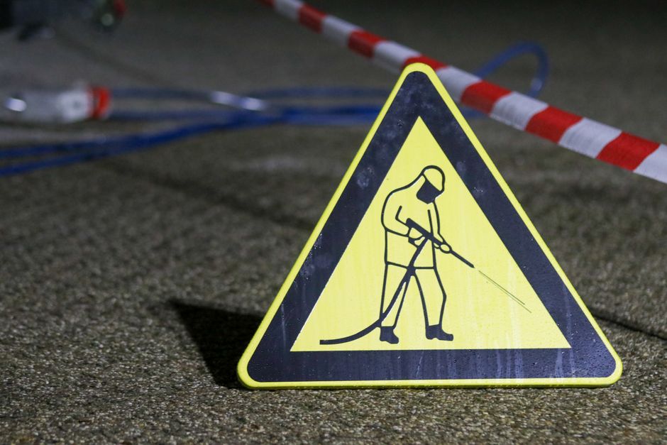 Sinal de advertência de trabalho de manutenção ou obras na rua, destacando a importância da segurança em projetos de infraestrutura.