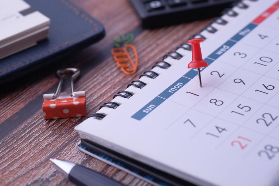 Imagem de um calendário com um alfinete vermelho marcando uma data importante, representando planejamento e organização de eventos ou prazos.