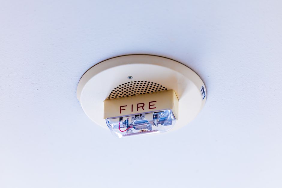 Detectado um sistema de alarme de incêndio instalado no teto de um ambiente interno.