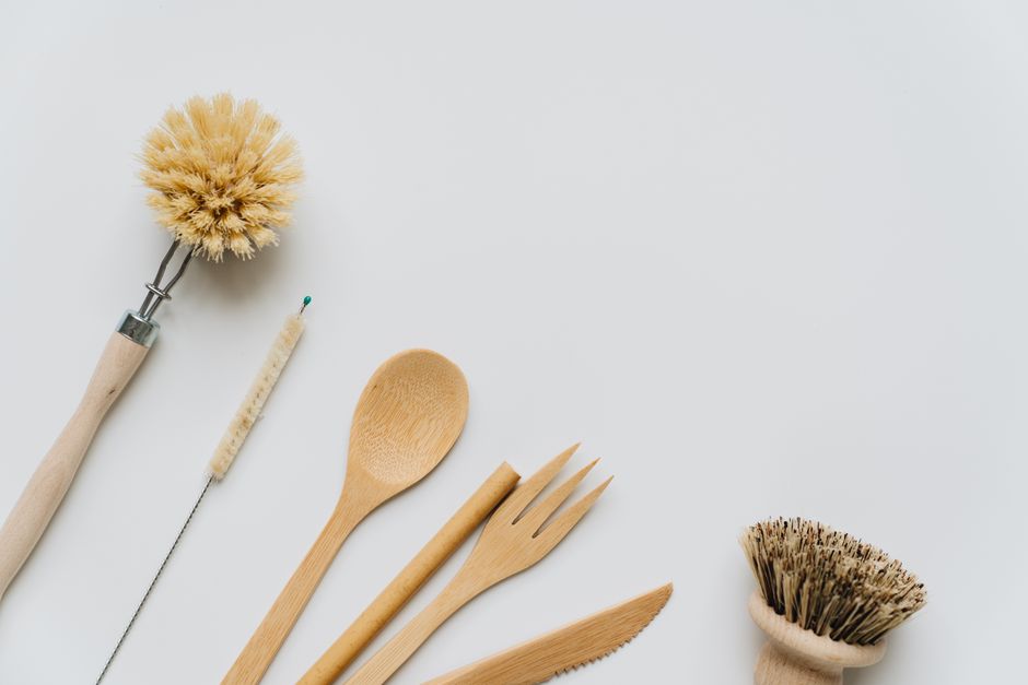 Imagem com utensílios de limpeza ecológicos de madeira e fibras naturais, simbolizando sustentabilidade e preservação ambiental.