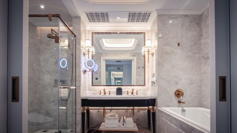 Banheiro de luxo com design sofisticado, featuring iluminação elegante e detalhes em cobre, perfeito para artigos sobre decoração de interiores de alto padrão.