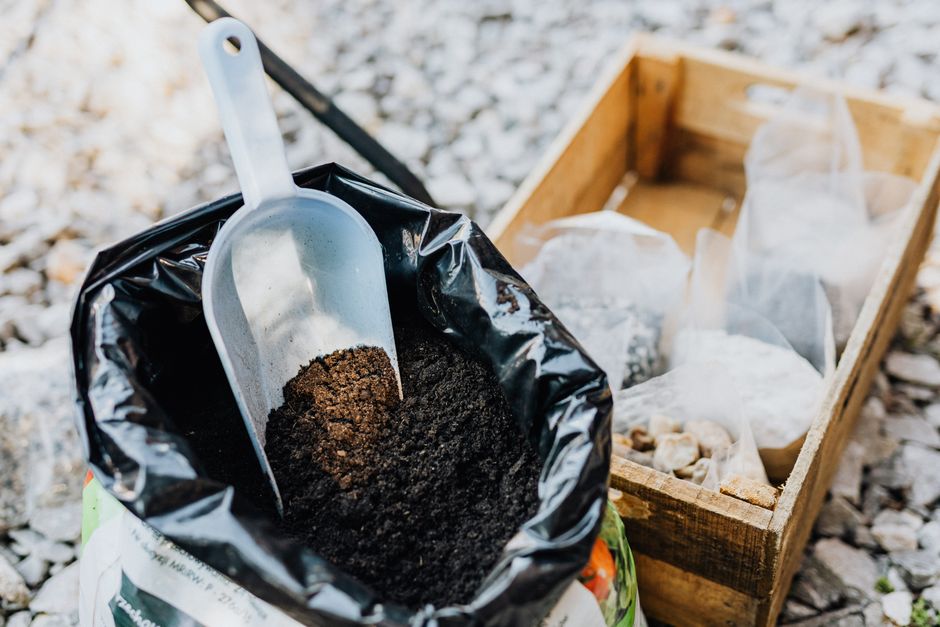 Imagem de uma ferramenta de jardinagem com terra, indicada para artigos sobre cultivo de plantas, jardinagem doméstica ou agricultura urbana.