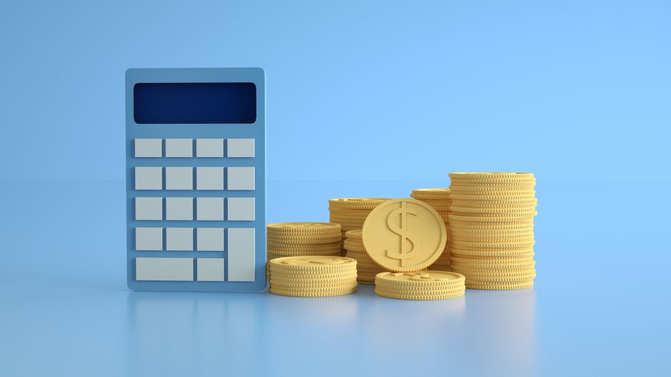 Imagem ilustrativa de finanças mostrando uma calculadora ao lado de pilhas de moedas douradas, simbolizando controle financeiro ou investimentos.