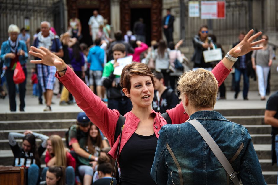 Mulher engajada em diálogo com uma pessoa mais velha durante uma manifestação ou protesto em ambiente urbano, refletindo ativismo ou debate social.