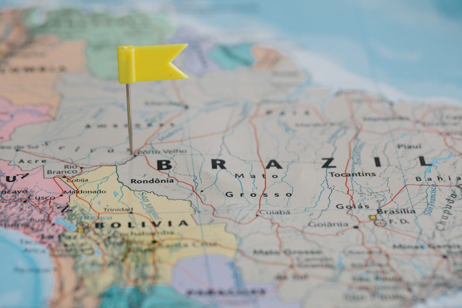 Mapa do Brasil com um marca-páginas amarelo indicando uma região, simbolizando planejamento de viagens ou estratégias geográficas.