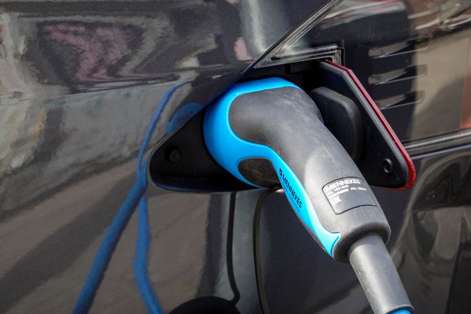 Veículo elétrico sendo carregado em ponto de recarga, destacando a inovação em transporte sustentável.