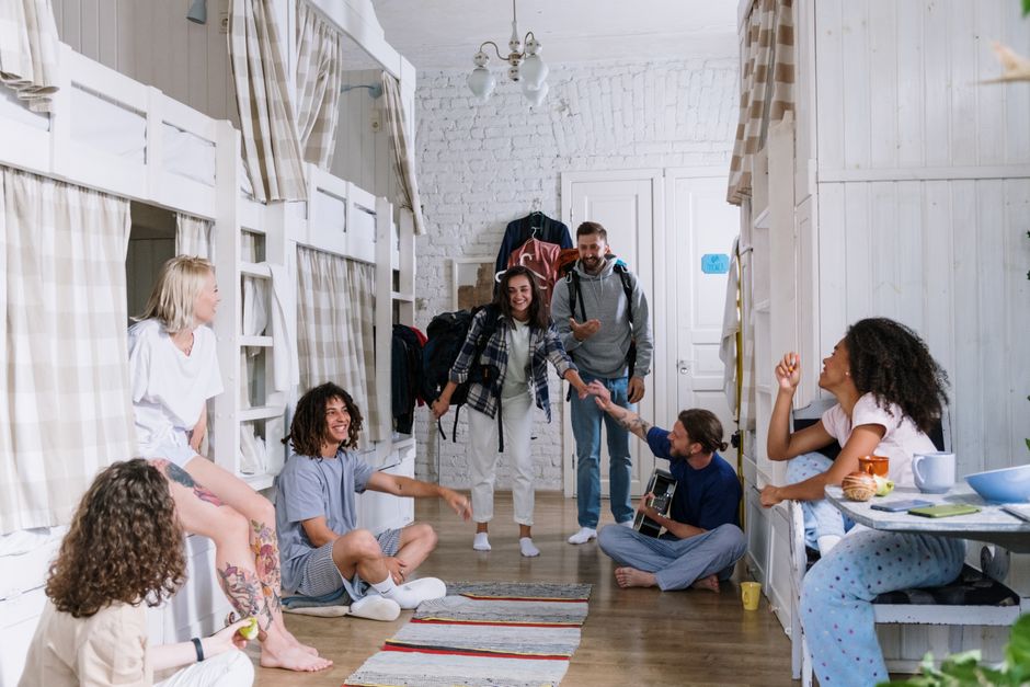 Grupo de jovens se reunindo em um ambiente acolhedor para conversar, trocar ideias ou se divertir, destacando interação social e convivência em espaço informal.