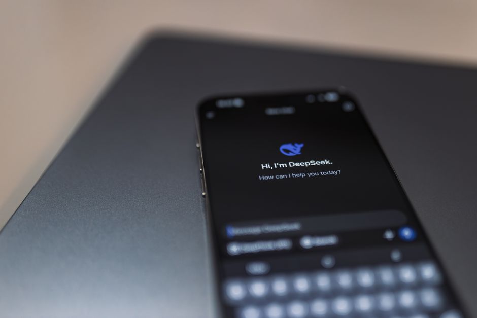 Imagem de um smartphone com tela do aplicativo DeepSeek, sugerindo tecnologia de inteligência artificial para suporte empresarial.