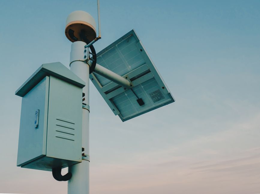 Imagem de uma câmera de segurança alimentada por energia solar instalada ao ar livre, simbolizando tecnologia e segurança pública.