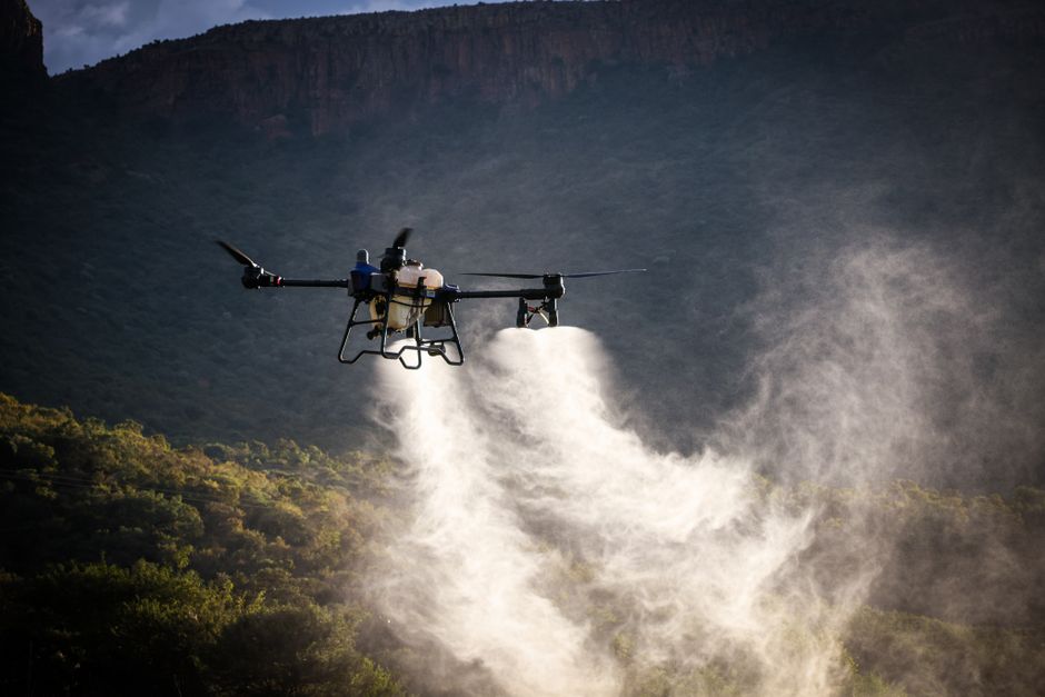 Drone pulverizando fertilizantes ou defensivos em uma área agrícola no campo.