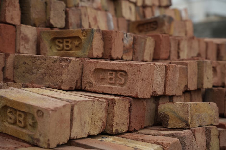 Fileira de tijolos de construção empilhados, prontos para uso em obras civis.