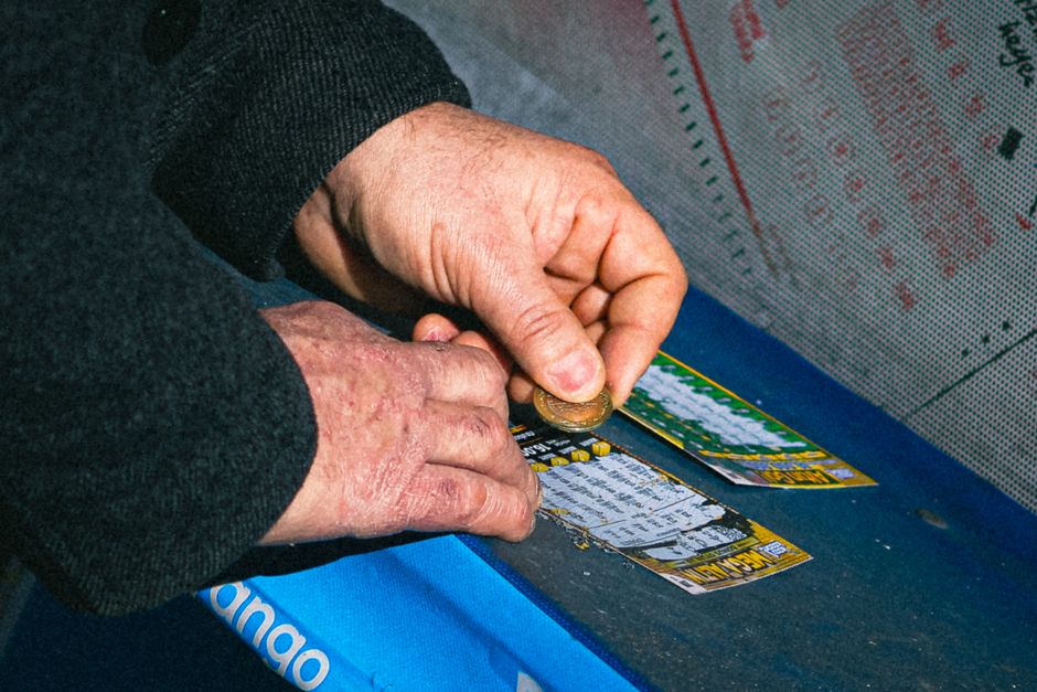 Pessoa colocando moedas em uma máquina de apostas, destacando o tema de jogos de azar e entretenimento