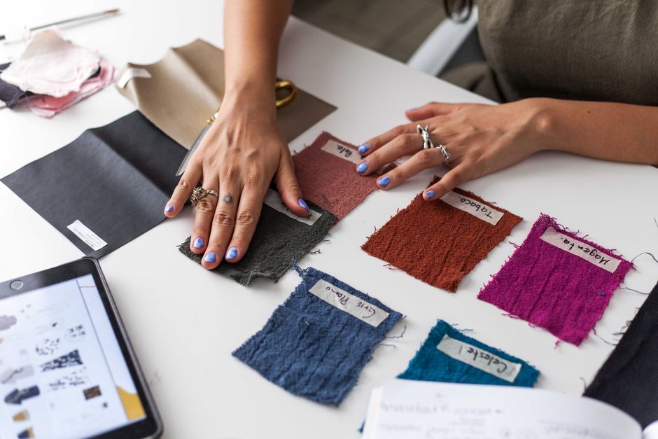 Pessoa acompanhando testes de cores e tecidos em processo de seleção para projeto de moda ou design de interiores.