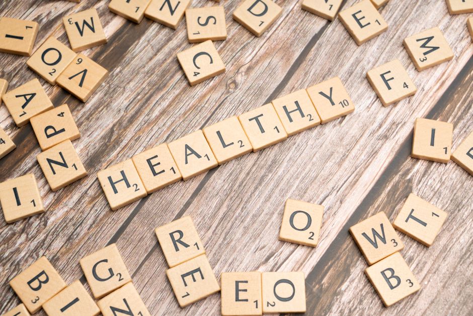 Imagem de peças de encaixe palavras formando a frase 'HEALTHY FOOD', representando temas de alimentação saudável e bem-estar.