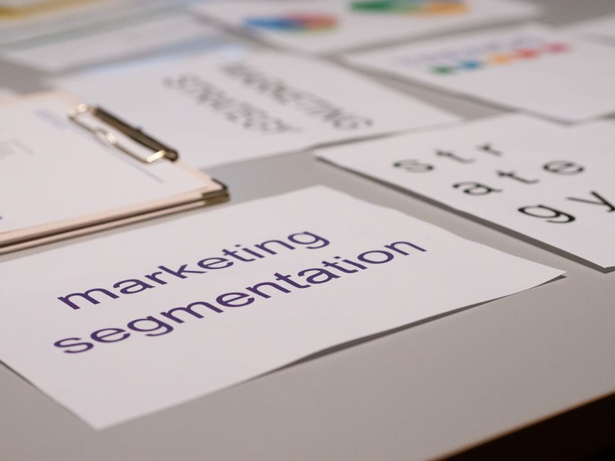 Imagem de uma mesa de trabalho com papéis e cartões relacionados à segmentação de mercado, voltada para estratégias de marketing.