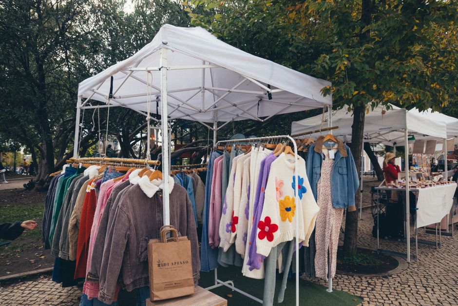 Imagem de uma feira ao ar livre exibindo roupas de verão e acessórios, ideal para um blog sobre moda sustentável ou comércio de rua.