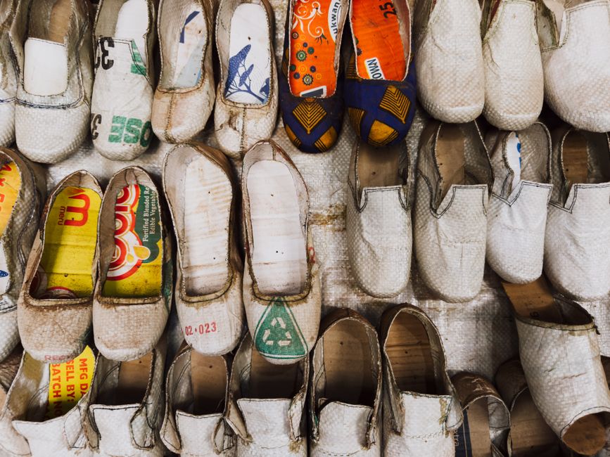 Imagem de sapatos feitos de materiais reciclados, destacando a criatividade no reaproveitamento de resíduos para confecção de calçados.