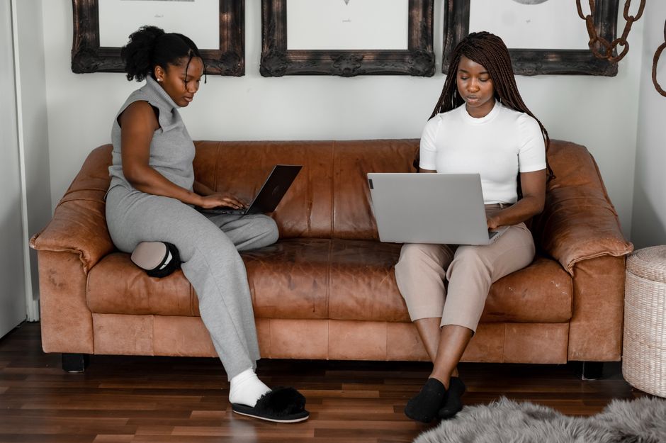 Duas mulheres trabalhando com laptops em um ambiente de home office, demonstrando produtividade e colaboração remota.
