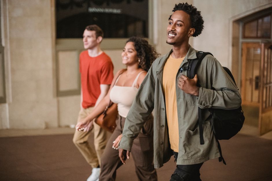 Grupo de jovens caminhando confiantemente em um ambiente urbano, transmitindo uma sensação de amizade e otimismo para um artigo sobre inclusão social e diversidade.
