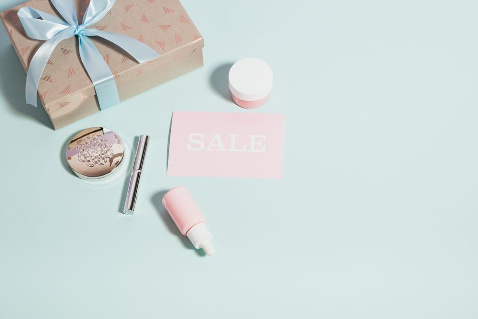 Imagem de produtos de beleza e maquiagem com um cartão de sale, ideal para artigos sobre promoções, cuidados pessoais ou tendências de beleza.